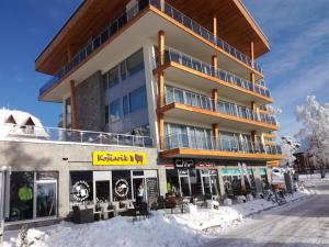 ein Gebäude mit Schnee davor in der Unterkunft Apartmán B 101 Vysoké Tatry in Starý Smokovec