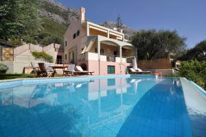 uma villa com piscina em frente a uma casa em Villa Iris em Barbati