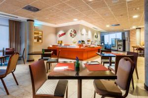 restauracja ze stołami, krzesłami i ladą w obiekcie Hotel Isla de La Garena w mieście Alcalá de Henares
