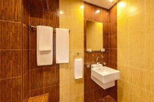 y baño con lavabo, espejo y toallas. en Eleganza Family Hotel en Sofía