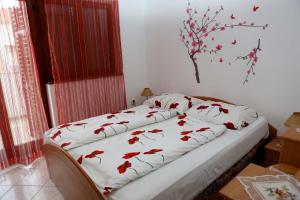 een slaapkamer met een bed met rode bloemen erop bij Apartment Zeljko 63 in Pula