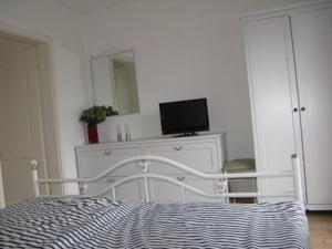 シェーンハーゲンにあるFerienwohnung S_stjernのベッドルーム1室(ベッド1台、ドレッサー、テレビ付)