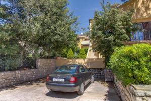 a car parked in a driveway in front of a house at Apartments Emma in Mali Lošinj