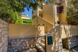 budynek z kamienną ścianą i schodami z przodu w obiekcie Apartments Emma w miejscowości Mali Lošinj