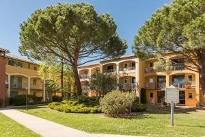 een groot appartementencomplex met bomen en een stoep bij Résidence Pierre & Vacances Les Rives de Cannes Mandelieu in Mandelieu-la-Napoule