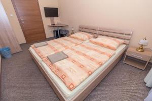 een slaapkamer met een groot bed met een houten frame bij Penzión Kastelán in Bojnice