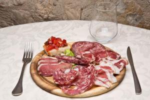 a plate of meat on a table with a fork and knife at Agriturismo Verniano Five Apartments with Panoramic Pool in Pieve a Scuola +90 photos