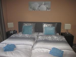 a bed with two blue pillows on top of it at Emderhaus in Emden