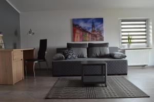 a living room with a couch and a table at Studio nad Jeziorem in Poznań