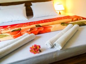 a hotel room with two beds with towels and flowers on them at Heaven Hills Guest House in Maskeliya