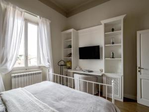 a bedroom with a bed and a desk and a window at Casa Desy in Forte dei Marmi