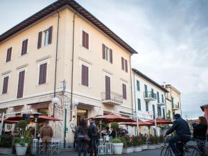 a group of people walking down a street next to a building at Casa Desy in Forte dei Marmi