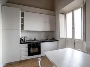 une cuisine avec des placards blancs et une table blanche dans l'établissement Casa Desy, à Forte dei Marmi