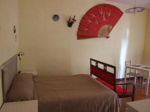 ミラッツォにあるMare Limpidoのベッドルーム1室(ベッド1台付)、壁に赤い傘が備わります。