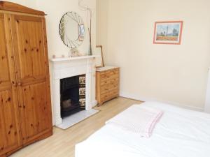 a white bedroom with a fireplace and a bed at Spacious West London 2 Bedroom Apartment in London