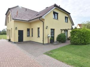 a large yellow house with a brick driveway at Comfortable Apartment in Kuhlungsborn Near Sea in Kühlungsborn