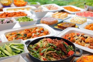 una mesa cubierta con bandejas de diferentes tipos de alimentos en Palace Hotel Tachikawa, en Tachikawa