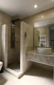a bathroom with a sink and a mirror and a tub at Mare Vista Hotel - Epaminondas in Batsi