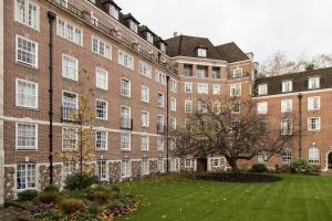 un gran edificio de ladrillo con un árbol delante de él en Goodenough College – University Residence, en Londres