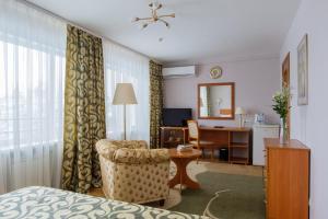 a hotel room with a bed and a chair and a desk at Syktyvkar Hotel in Syktyvkar