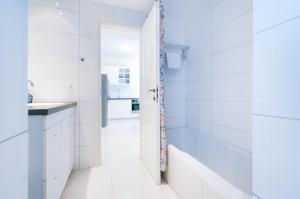a white bathroom with a tub and a sink at Colony Suites - Hildesheimer St. in Jerusalem +10 photos