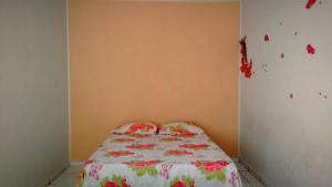 um quarto com uma cama com colcha floral em Pousada CPA em Cuiabá