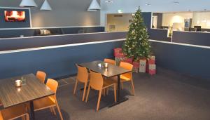 a christmas tree in a restaurant with tables and chairs at Hotell Charlottenberg in Charlottenberg