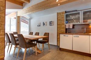 eine Küche und ein Esszimmer mit einem Holztisch und Stühlen in der Unterkunft Haus Mattle in Pettneu am Arlberg