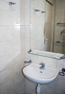 y baño con lavabo y espejo. en Kambarių nuoma - Šiauliai SAURIDA, en Šiauliai