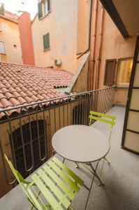 a white table and two chairs on a balcony at Azeglio apartment, a due passi da Piazza Maggiore in Bologna