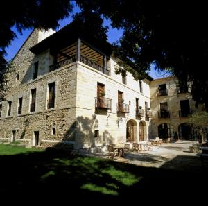 un gran edificio de piedra con balcón. en Parador de Santillana Gil Blas, en Santillana del Mar