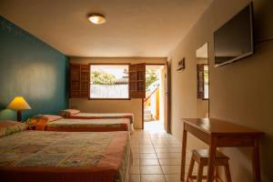 a hotel room with two beds and a desk at Pousada Bemvirá in Arraial d'Ajuda +90 photos
