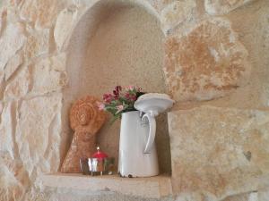 a vase with flowers on a shelf in a stone wall at Estudio rural Estrella Polar III in Huerta
