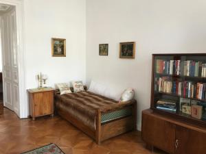 een kamer met een bank en een boekenplank met boeken bij 88m² großes Apartment im 1. Stock in Wenen