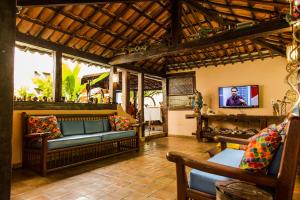 a living room with a couch and a tv at Pousada Bemvirá in Arraial d'Ajuda