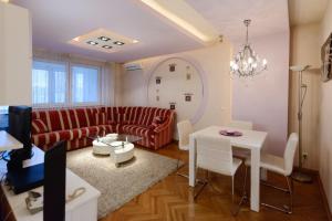 a living room with a red couch and a table at Garni Hotel Crystal in Kraljevo