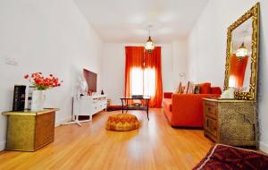 マラガにあるSerendipity Apartmentsのリビングルーム(オレンジ色のソファ、鏡付)