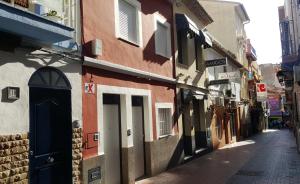 a narrow alley with buildings on a street at APLUS Apartamentos, Old Town Benidorm in Benidorm