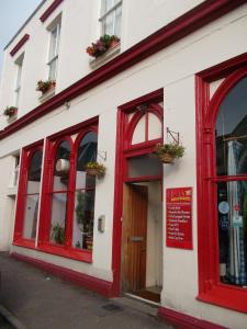 un edificio rosso e bianco con finestre e porta di Oban Backpackers a Oban