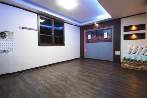 a room with white walls and a hard wood floor at Palgongsan Maeksomseok Youth Hostel in Daegu