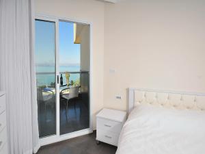 a bedroom with a bed and a balcony with a table at מגדלי המלכים נופש משפחתי in Tiberias
