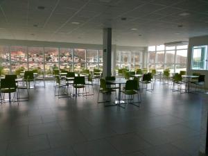 Cette grande chambre dispose de tables, de chaises et de fenêtres. dans l'établissement Brito Hotel, à Resplendor