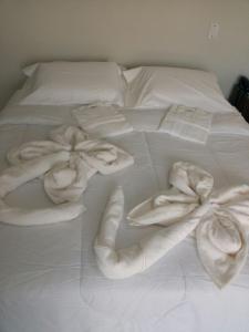 a white bed with white towels on it at Brito Hotel in Resplendor