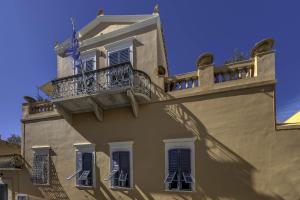 a building with a balcony on the side of it at Arhontiko Ermoupolis in Ermoupoli