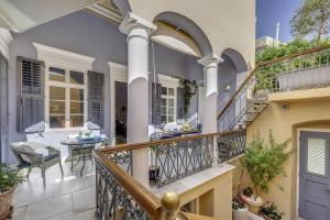a home with a balcony with a table at Arhontiko Ermoupolis in Ermoupoli
