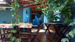 una sala da pranzo con tavoli, sedie e piante di Pousada Bugio a Abraão
