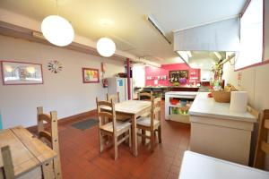 una cucina con tavolo, sedie e frigorifero di Oban Backpackers a Oban