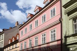 ein rosafarbenes Gebäude an der Straßenseite in der Unterkunft Hotel Residence Agnes in Prag