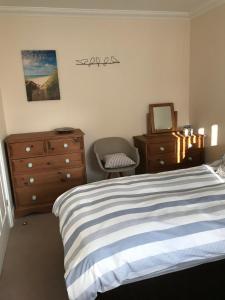 1 dormitorio con cama, tocador y espejo en The Lookout, en Mundesley