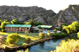 a resort with a river and mountains in the background at Hotel Valle Grande in San Rafael